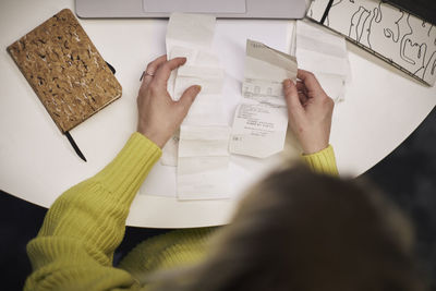 Businesswoman checking receipts in office