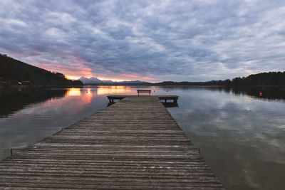 Pier over lake against sky during sunset