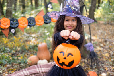 Halloween. cute arab girl in witch costume with jack o lantern outdoor