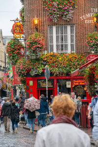 Rear view of people walking on street against buildings