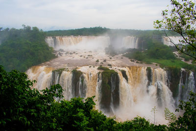 Scenic view of waterfall against sky