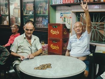 Happy friends sitting on table at restaurant