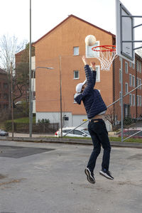 Teenage boy scoring basketball shot