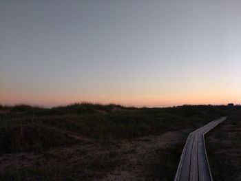 Scenic view of field against clear sky during sunset