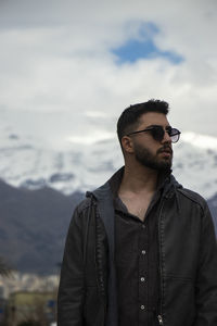 Young man standing against mountain