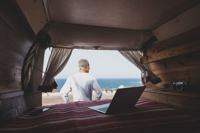 Rear view of man sitting at home