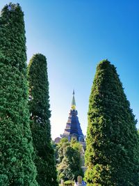 Low angle view of trees and building against sky