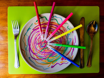 Directly above shot of multi colored candies in plate on table