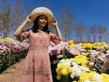 Young woman standing by flowering plants