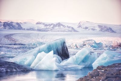 Icebergs in sea against sky