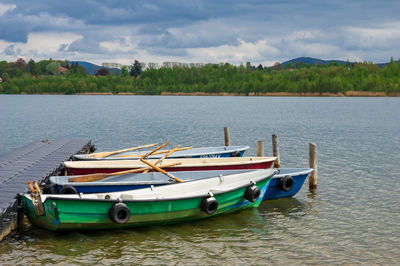 Boats moored in lake against sky