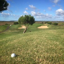 Scenic view of golf course against sky