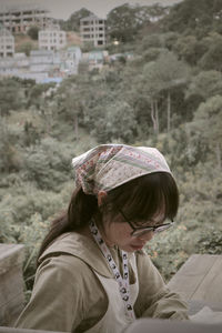 Rear view of woman sitting on field