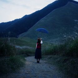 Rear view of woman standing on landscape