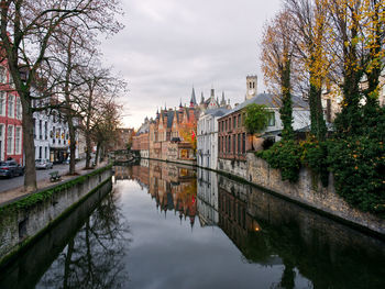 Canal amidst buildings against sky