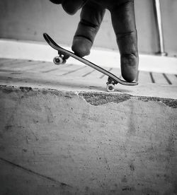 Human fingers riding tiny skateboard