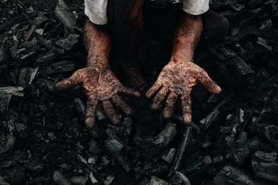 Low section of man showing messy hands working on logs