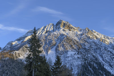 Low angle view of snowcapped mountain against sky