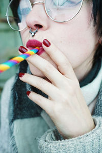 Close-up of mid adult woman holding straw in mouth