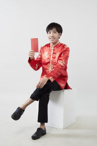 Full length of happy girl holding umbrella against white background