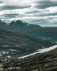 Scenic view of sea and mountains against sky