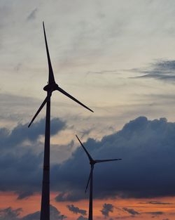 Low angle view of wind turbine against sky during sunset