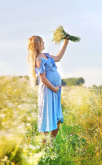 Rear view of woman standing on grassy field