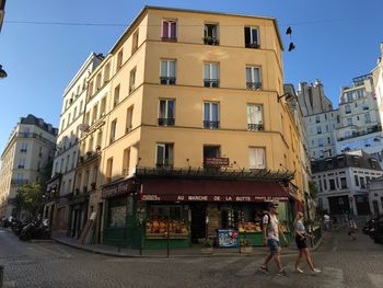 People walking on street against buildings in city