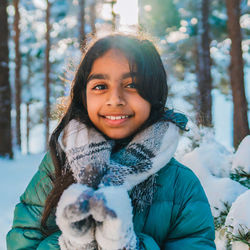 The joy of the winter. portrait of smiling young girl in a snowcapped forest.