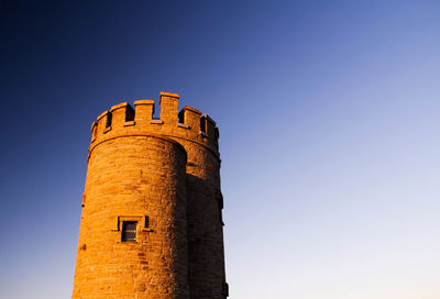 Low angle view of clock tower against clear sky