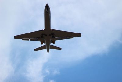 Low angle view of airplane flying against sky