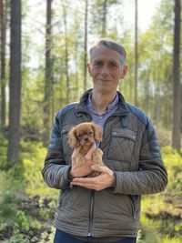 Portrait of man with dog in forest