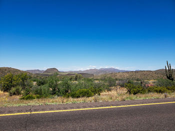 Scenic view of road against clear blue sky