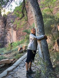 Portrait of happy woman hugging tree at zion national park