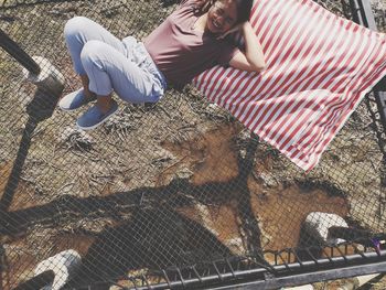 High angle view of smiling woman lying on net