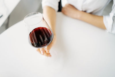 Midsection of woman holding light bulb against white background