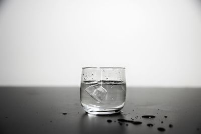 Glass of water on table against white background