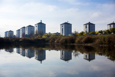 Buildings reflected in falchera lake in turin italy