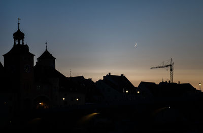 Silhouette buildings against sky at dusk