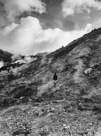 Man walking on rock covered land