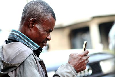 Side view of mature man using mobile phone