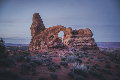 Rock formation on landscape against sky