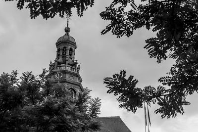 Low angle view of trees and building against sky