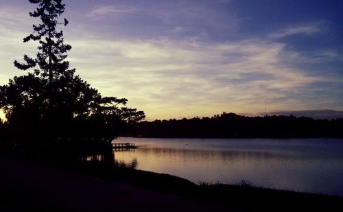 Silhouette of trees and lake at sunset