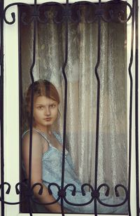 Close-up of young woman standing against wall