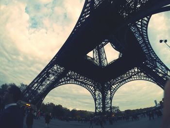 Low angle view of bridge against cloudy sky