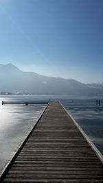 Pier over lake against blue sky