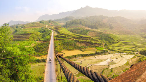 High angle view of people riding motorcycle on bridge against sky