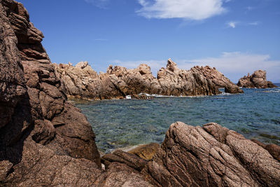 Scenic view of rocks in sea against sky