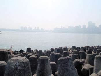 Sea by city buildings against sky